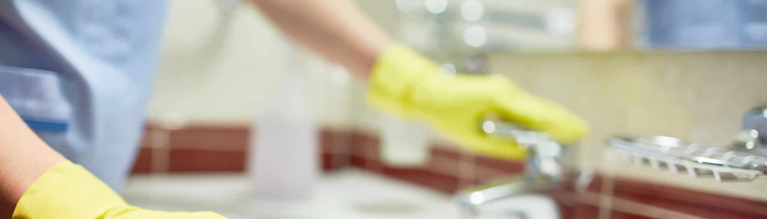 Janitor-cleaning-up-public-bathroom-in-business-building Janitor Cleaning Up Public Bathroom In Business Building