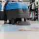 Image of a worker buffing tile floors in a retail store.