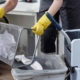 Image of a cleaning service person emptying office trash bins.