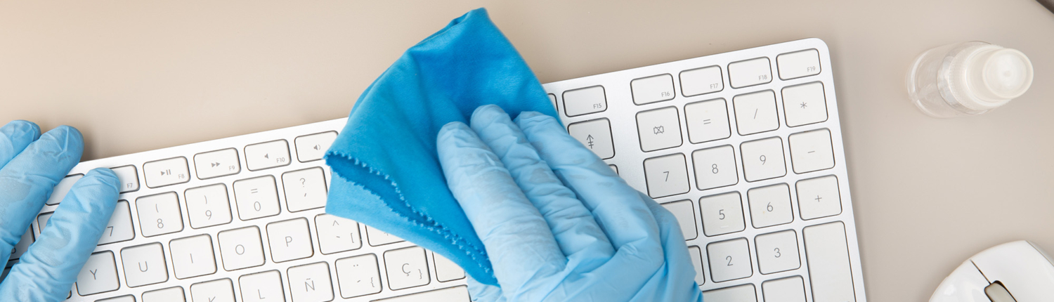Overhead View Of A Person Wiping Off A Keyboard