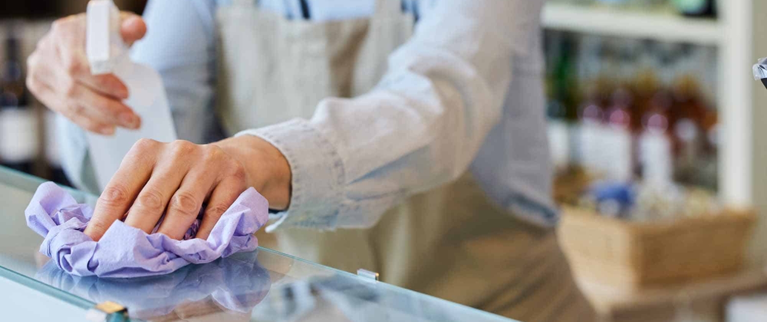 woman wiping a counter in a grocery store