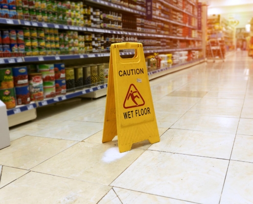 Wet floor sign in aisle of grocery store