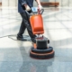Image of a janitor buffing a tiled floor.