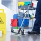 Worker janitor Mopping Floor In Office with trolley