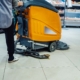 Worker Using Machine To Clean Retail Floors