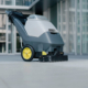 The Worker Is Using A Floor Scrubber To Clean The Floor